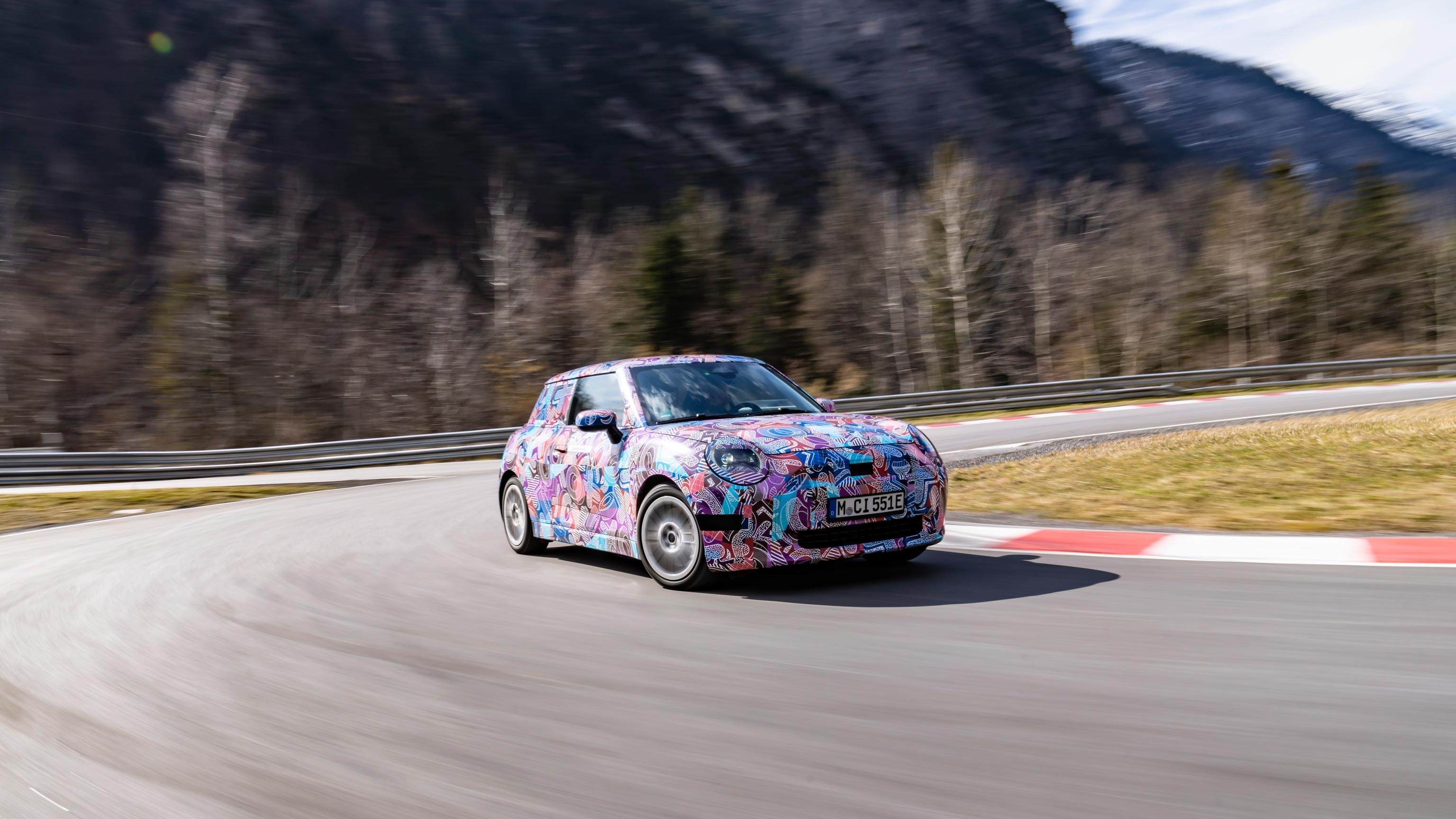 Side front view of the MINI Cooper Electric driving on a road.